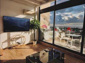 a living room with a flat screen tv and a balcony at Apartamentos Vacacionales Madrid España in Madrid