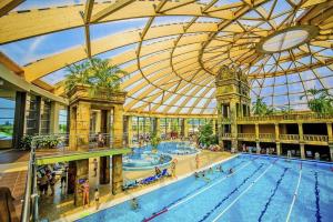 a large swimming pool in a building with a large ceiling at Otthonos lakás in Kerepes
