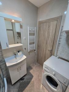 Un baño con lavadora y lavabo. en Apartman Emi, en Belgrado