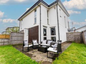 a white house with chairs and a couch in the yard at Etihad Stadium Stay for Contractors with Free Parking & Wifi Near The City Stays in Manchester