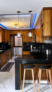 une cuisine avec un comptoir noir et des armoires en bois dans l'établissement casa con piscina cerca de la playa Caleta 8 mnt de casa de campo Residencial los garcia la romana, à La Romana