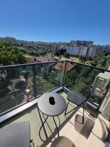ベオグラードにあるPark residence Apartman 2, Mirijevo, Serbiaの建物の上にテーブルと椅子が置かれたバルコニー