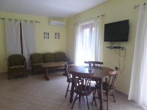 a living room with a table and chairs and a television at Apartment Jana in Štinjan