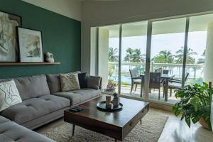 a living room with a couch and a table at Departamento Mayan Island - A pie de playa y con albercas in Acapulco