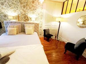Un dormitorio con una gran cama blanca y una silla. en Cosy campagne, en Pont-sur-Seine