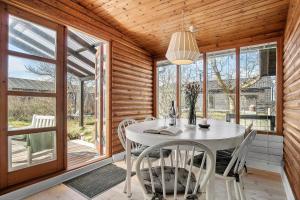 a dining room with a table and chairs and windows at SL243-Skaelskor-Hybenvej-30 in Skælskør +19 photos