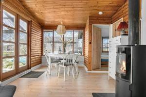 a dining room with a table and a fireplace at SL243-Skaelskor-Hybenvej-30 in Skælskør