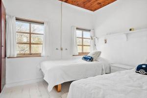 two beds in a white room with two windows at SL243-Skaelskor-Hybenvej-30 in Skælskør