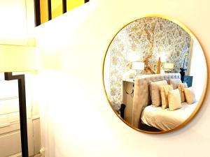 espejo en la pared con cama en la habitación en Cosy campagne, en Pont-sur-Seine 1 foto más