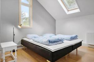 a bed in a white room with a window at K19007-Kalundborg-Strandskraenten-11 in Kalundborg