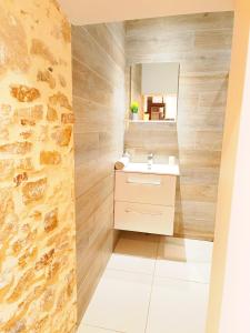 Un baño con lavabo y pared de piedra. en Cosy campagne, en Pont-sur-Seine