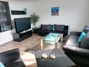 a living room with couches and a tv at Ferienwohnung am Hopfengarten in Illschwang