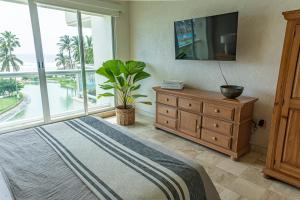 a bedroom with a bed and a large window at Departamento Mayan Island - A pie de playa y con albercas in Acapulco