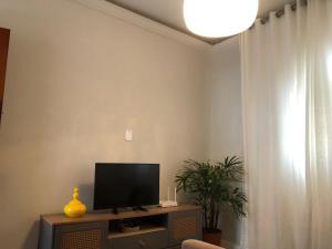 a living room with a flat screen tv on a table at Flat Aconchegante e Conectado in Teófilo Otoni