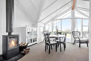 a dining room with a fireplace and a table and chairs at SL310-Slagelse-Birkevej-49 in Slagelse