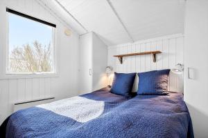 a bedroom with a bed with blue sheets and a window at SL310-Slagelse-Birkevej-49 in Slagelse