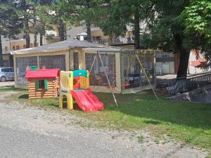 a playground with a play set and a house at La piccola baita in Pieve Santo Stefano