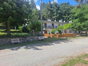 a house with two benches on the side of a road at La piccola baita in Pieve Santo Stefano