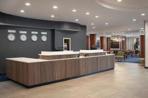 a lobby with a counter with clocks on the wall at Courtyard Boston-South Boston in Boston