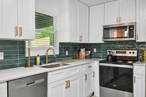 a kitchen with white cabinets and a sink and a stove at Upscale 4BR Residence Quick Access to Downtown in Austin