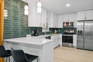 a kitchen with white cabinets and stainless steel appliances at Upscale 4BR Residence Quick Access to Downtown in Austin +128 photos