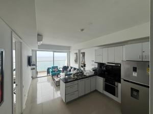 une cuisine avec des armoires blanches et une vue sur l'océan dans l'établissement Playa Cartagena Apartments, à Carthagène des Indes