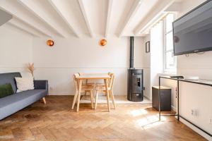 a living room with a table and a couch at L'Ermitage in Rambouillet