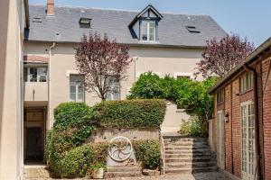 una casa con scale di fronte a un edificio di L'Ermitage a Rambouillet