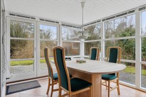Un comedor con mesa y sillas y ventanas. en K20089-Store-Fuglede-Tjornelunden-30, en Store Fuglede