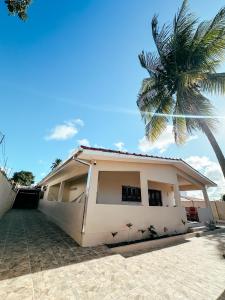 ein Haus mit einer Palme davor in der Unterkunft CasAMAR - casa de praia na terra das piscinas naturais - PE in São José da Coroa Grande