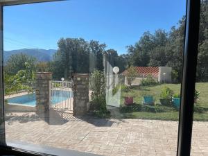 a view of a backyard with a pool and a fence at villa calme et detente in Montbolo