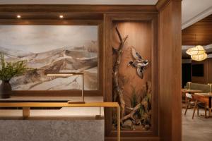 a dining room with a painting of birds on the wall at Kananaskis Mountain Lodge, Autograph Collection in Kananaskis Village