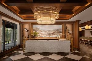 a lobby with a chandelier and a reception desk at Kananaskis Mountain Lodge, Autograph Collection in Kananaskis Village