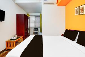 a bedroom with a large bed and a chair at Super Collection O Banaswadi in Bengaluru