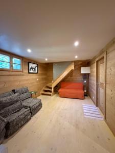 a living room with a couch and a staircase at Chalet des Hautes Côtes in Manigod
