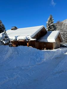 a house covered in snow with a pile of snow at Chalet des Hautes Côtes in Manigod