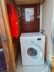a washer and dryer in a small room with a door at Le Jardin aux Oiseaux in Sainte-Anne +12 photos