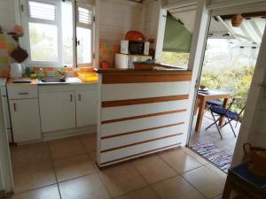 a kitchen with white cabinets and a counter top at Le Jardin aux Oiseaux in Sainte-Anne