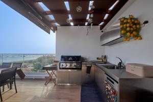 a kitchen with a sink and a counter with a view at Apartamentos Golfinho Dourado in Santa Maria