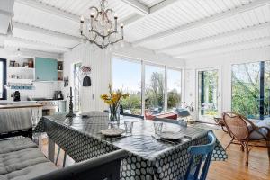 Langemark20617-Langemark-Samso-Egernvej-6的一间有桌子和枝形吊灯的餐厅