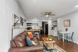 a living room with a brown leather couch and a kitchen at Shared Hot Tub & Pool Grill River Access in New Braunfels +17 photos
