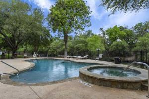 a swimming pool in a park with trees at Shared Hot Tub & Pool Grill River Access in New Braunfels