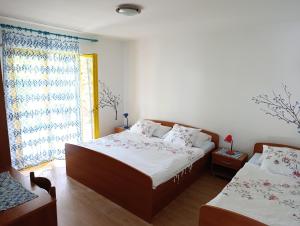 a bedroom with two beds and a window at Dada Apartments in Lopar +46 photos