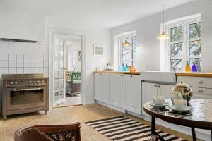 a kitchen with a table and a stove and a table at 20121-Samso-Landevejen-46-B in Nordby