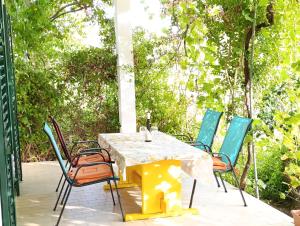 a yellow table and chairs on a patio at Dada Apartments in Lopar