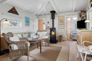 a living room with a couch and a table and a fireplace at 20508-Samso-Onsbjerg-Vestermark-63 in Sælvig