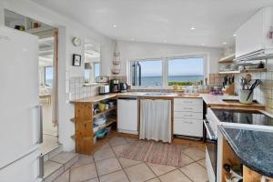 a kitchen with white cabinets and a view of the ocean at 20508-Samso-Onsbjerg-Vestermark-63 in Sælvig