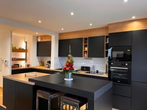 a kitchen with a black island with a vase of flowers on it at Chic apartment with panoramic view in Caen +11 photos