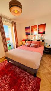 a bedroom with a large bed with a red rug at Chic apartment with panoramic view in Caen