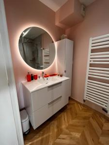 a bathroom with a white sink and a mirror at Chic apartment with panoramic view in Caen